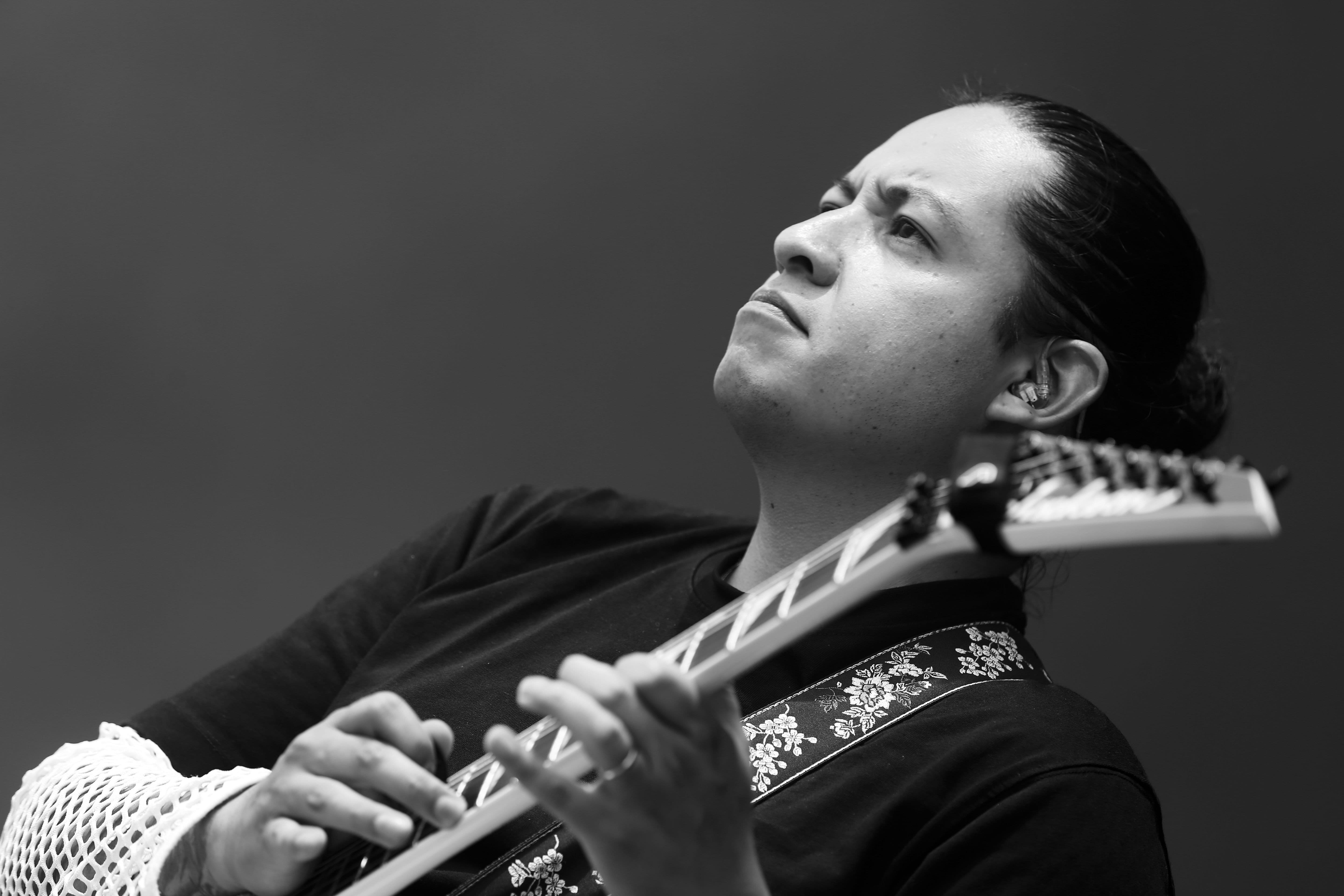 Metal guitarist Felipe Motta playing a lead using tapping technique on stage of an open air in Swtizerland